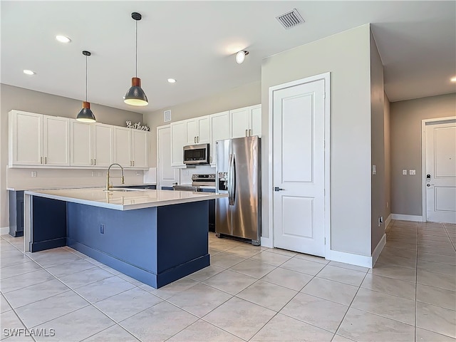 kitchen with stainless steel appliances, sink, pendant lighting, a center island with sink, and white cabinets