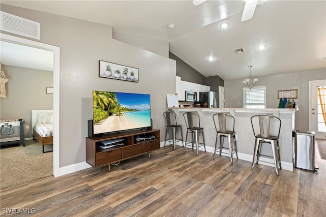 kitchen featuring a breakfast bar area, appliances with stainless steel finishes, white cabinets, carpet flooring, and kitchen peninsula