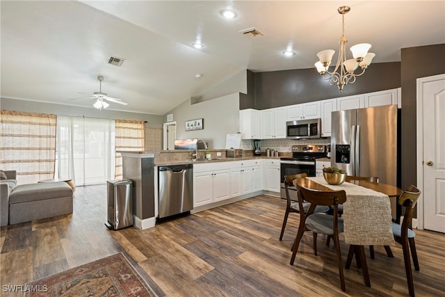 kitchen with ceiling fan with notable chandelier, appliances with stainless steel finishes, white cabinets, wood-type flooring, and sink