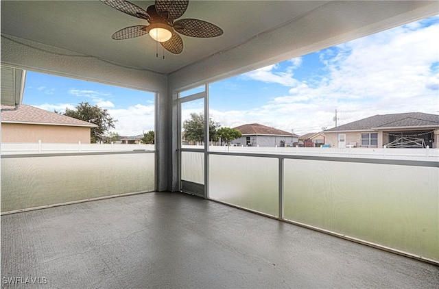 unfurnished sunroom with ceiling fan