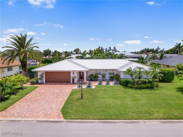 ranch-style house featuring a garage and a front lawn