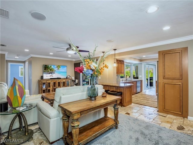 living room with sink, crown molding, and ceiling fan