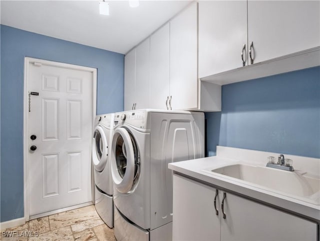 clothes washing area featuring cabinets, washer and clothes dryer, and sink