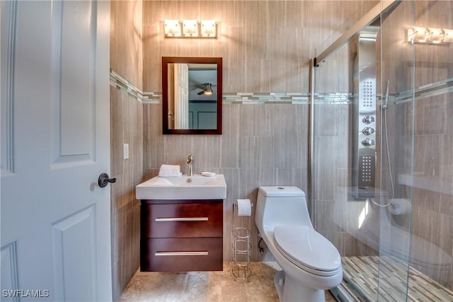 bathroom with vanity, tile walls, toilet, and walk in shower