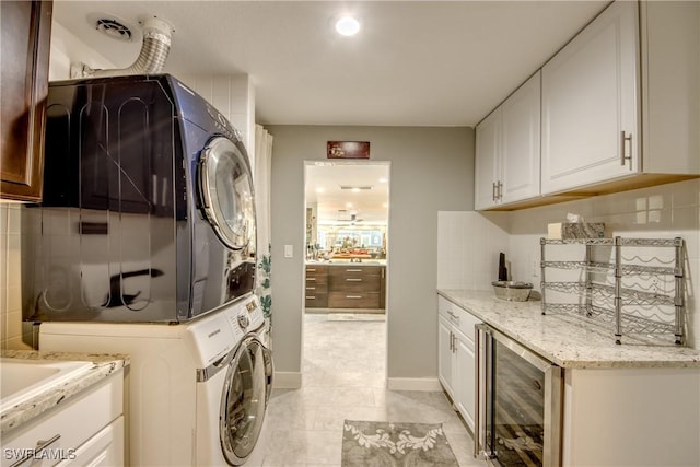 1862 Linhart Ave, Fort Myers, FL 33901 - laundry area with stacked washer and clothes dryer, beverage cooler, laundry area, light tile patterned flooring, and baseboards