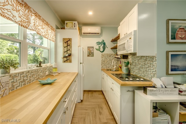 kitchen with white appliances, an AC wall unit, butcher block counters, and white cabinets