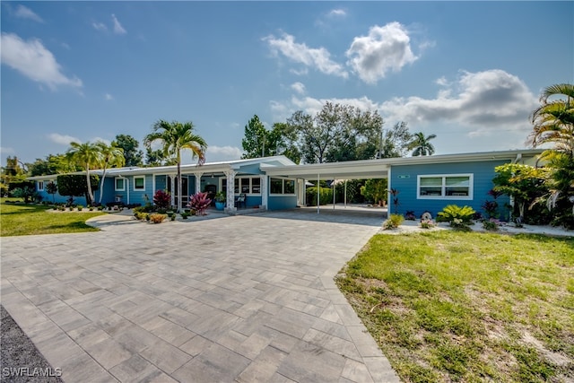 ranch-style home with a carport and a front lawn