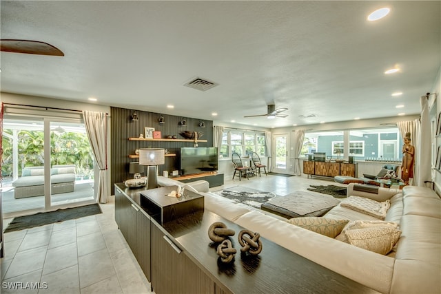 tiled living room featuring plenty of natural light and ceiling fan