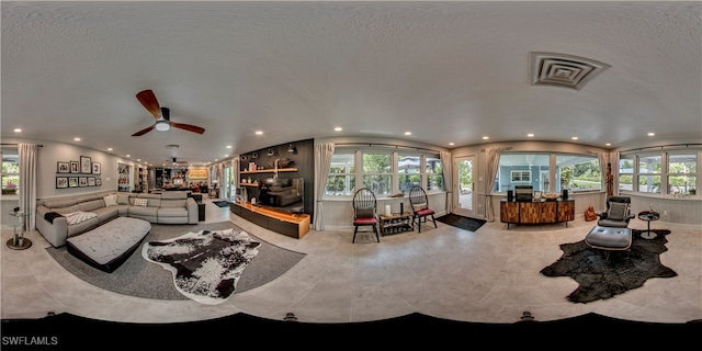 living room with a textured ceiling and ceiling fan