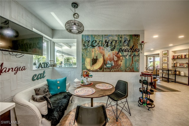 interior space with a textured ceiling, plenty of natural light, and a chandelier