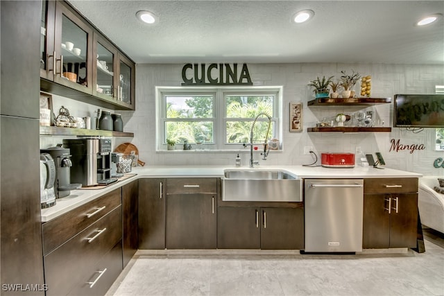 kitchen featuring dishwasher, sink, dark brown cabinetry, and a textured ceiling