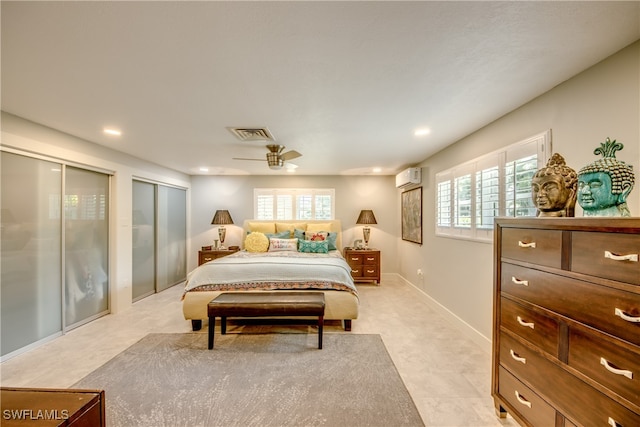 bedroom featuring a wall mounted AC, ceiling fan, and multiple closets