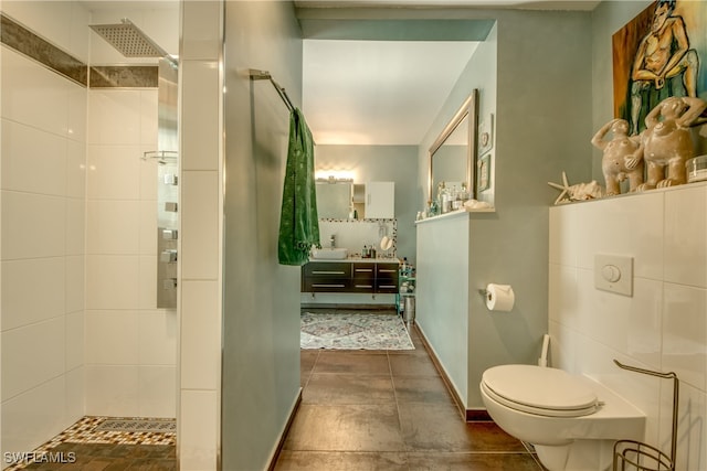 bathroom featuring vanity, toilet, and a tile shower