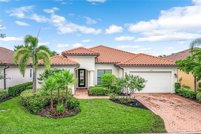 mediterranean / spanish-style house featuring a garage and a front yard