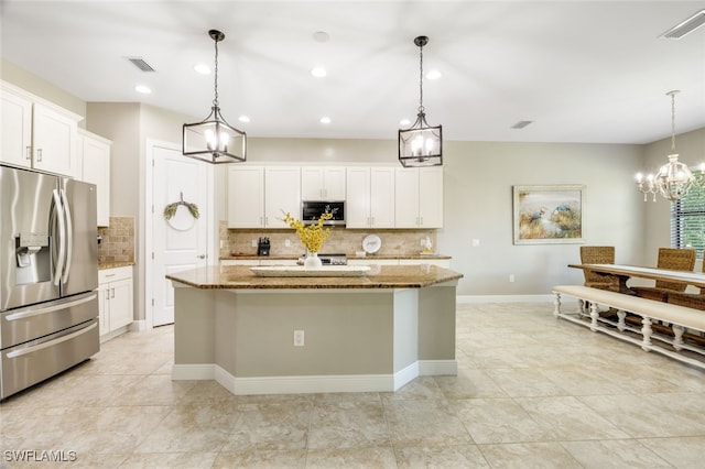 kitchen featuring pendant lighting, stainless steel appliances, and a center island with sink