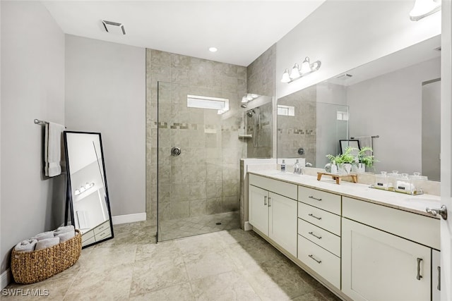 bathroom with vanity and tiled shower