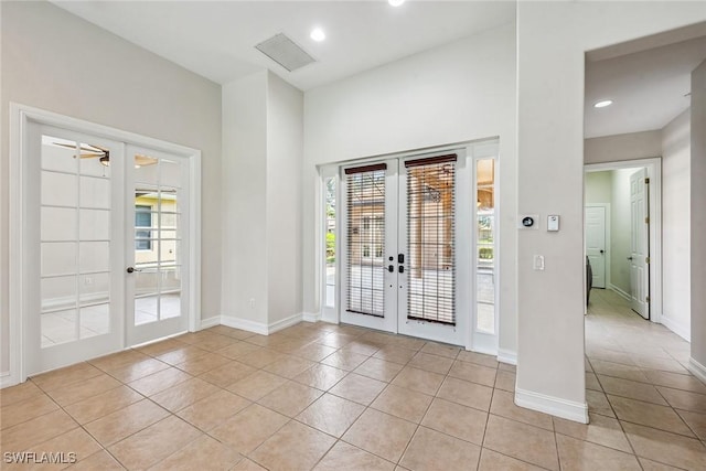 foyer entrance with light tile patterned floors, recessed lighting, french doors, and baseboards