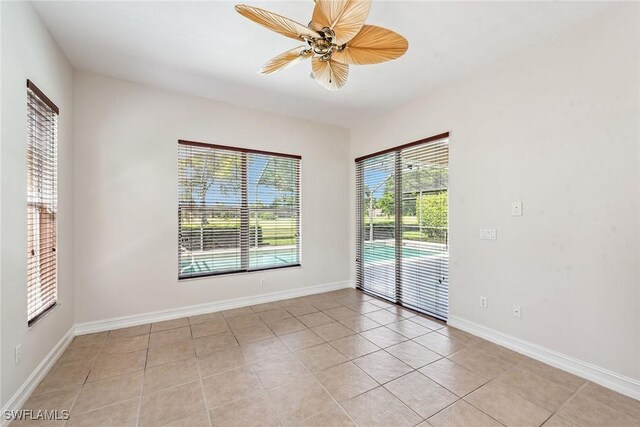 spare room with ceiling fan and light tile patterned floors