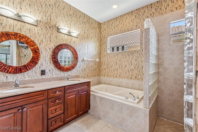 bathroom with tiled bath, double vanity, and tile patterned floors