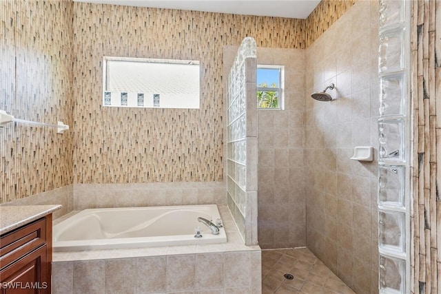 full bathroom featuring vanity, a bath, and tiled shower