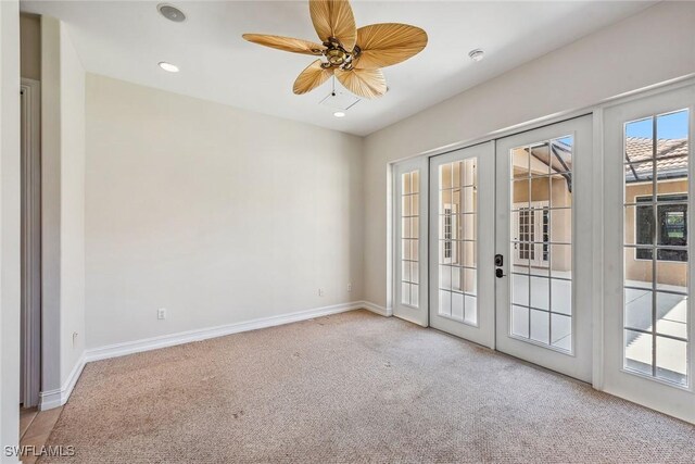 carpeted empty room featuring ceiling fan and french doors