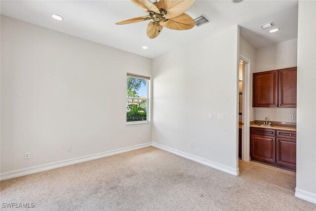 carpeted empty room with ceiling fan and sink