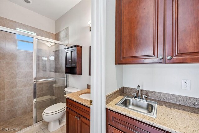 bathroom featuring a shower with door, toilet, tile patterned floors, and vanity