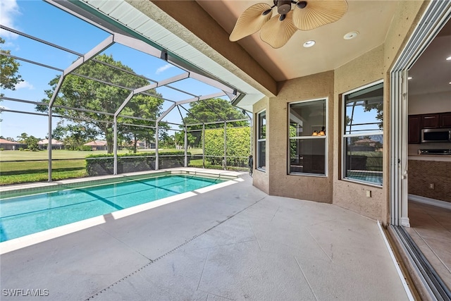 view of pool with ceiling fan, a lanai, and a patio