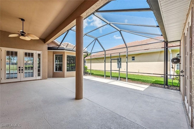 view of patio with glass enclosure, french doors, and a ceiling fan