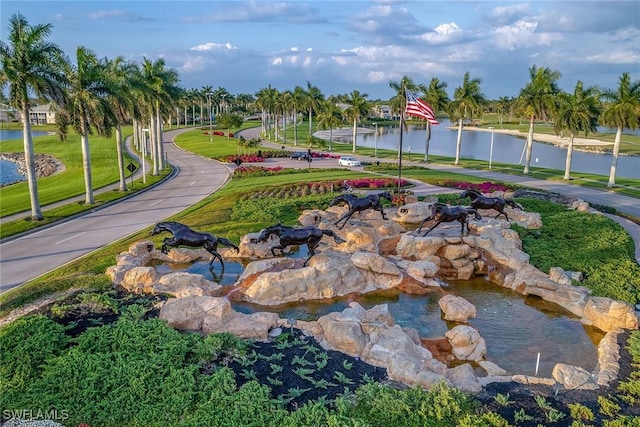 view of property's community featuring a yard and a water view