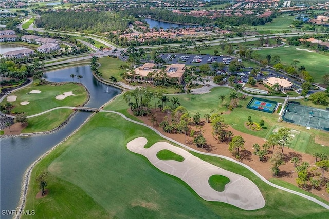 aerial view with golf course view and a water view