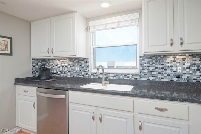 kitchen with dishwasher, tasteful backsplash, sink, and white cabinetry