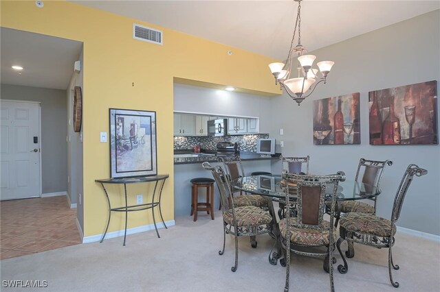 dining room with a notable chandelier and light tile patterned flooring