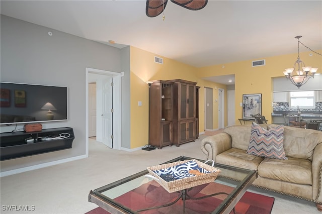 carpeted living room featuring an inviting chandelier