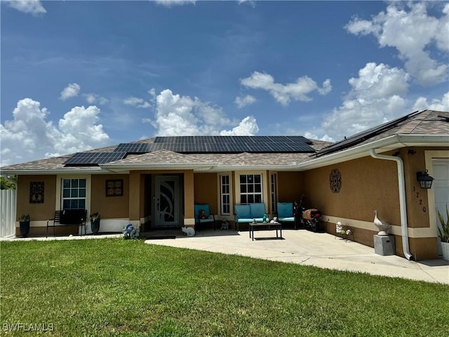 back of house with a patio, an outdoor hangout area, a yard, and solar panels