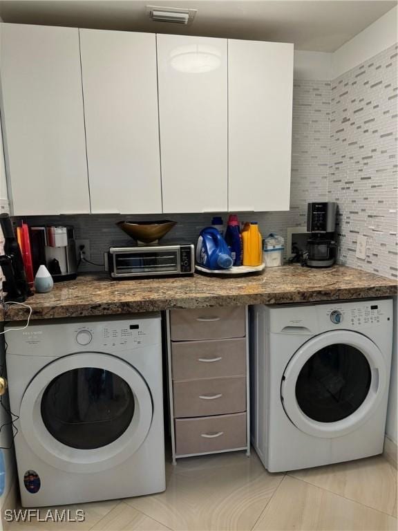 laundry room featuring cabinets and washer / dryer