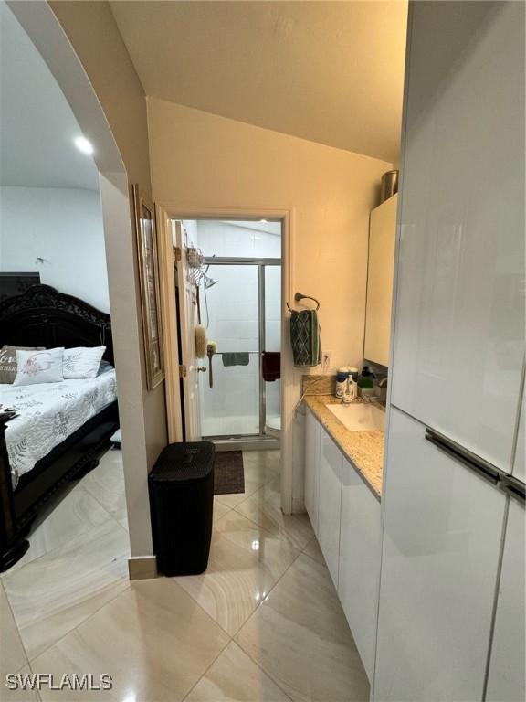 bathroom featuring vanity, lofted ceiling, and an enclosed shower