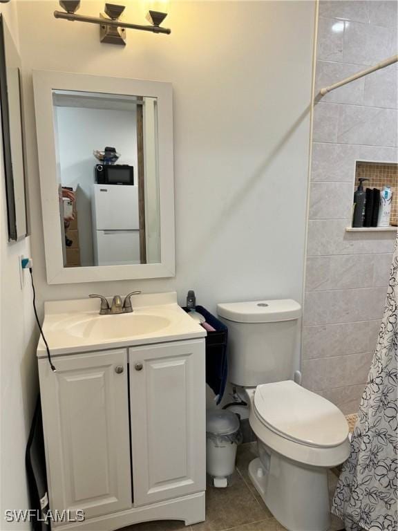 bathroom featuring vanity, toilet, and tile patterned flooring