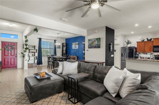 living room with light tile patterned floors, ceiling fan with notable chandelier, visible vents, and recessed lighting