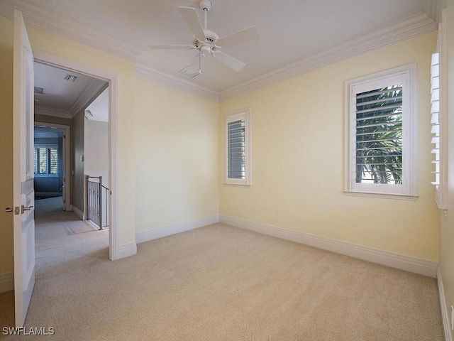 unfurnished room with light carpet, crown molding, and plenty of natural light