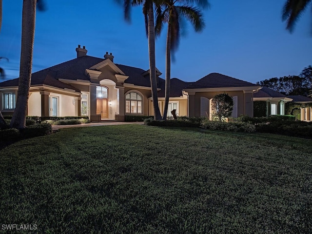 2835 Silverleaf Ln, Naples, FL 34105 - view of front of home with stucco siding, a front yard, and a chimney