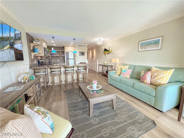 living room with light hardwood / wood-style flooring and ornamental molding