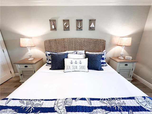 bedroom featuring ornamental molding and hardwood / wood-style flooring