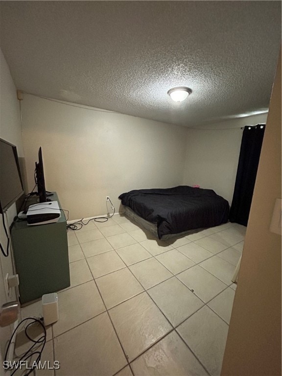 unfurnished bedroom with a textured ceiling and light tile patterned floors