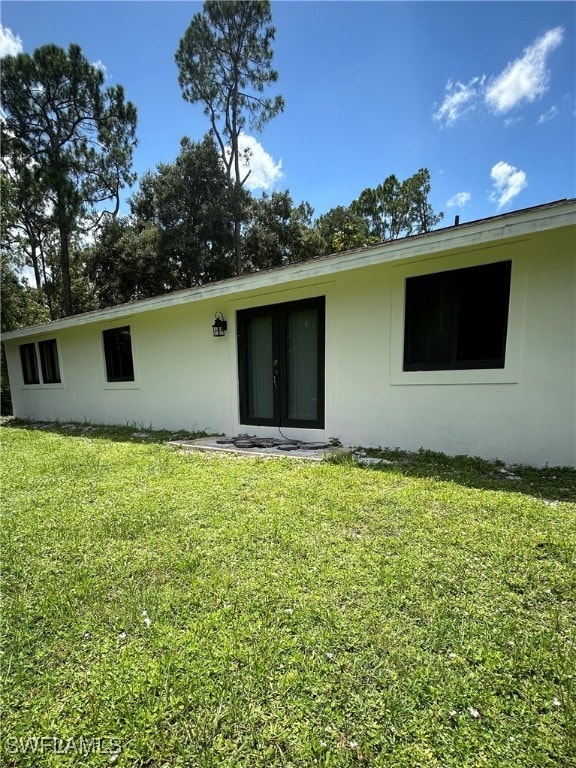 rear view of property with a lawn