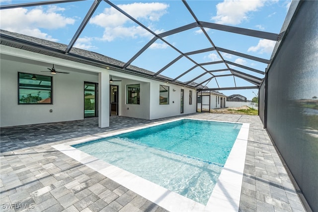 view of pool with ceiling fan, a lanai, and a patio