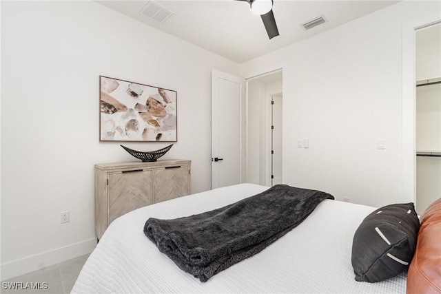 bedroom featuring ceiling fan, a spacious closet, light tile patterned floors, and a closet