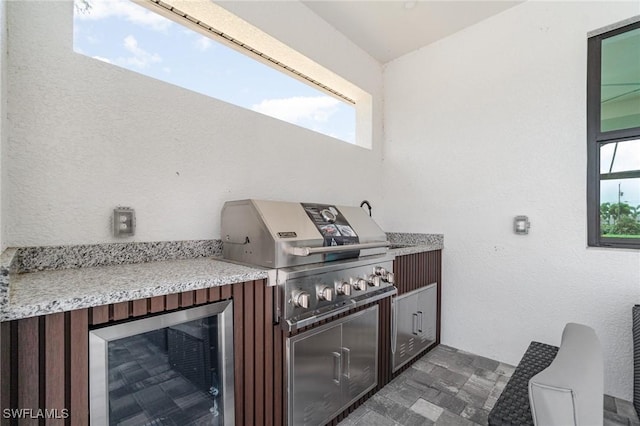 view of patio / terrace featuring wine cooler, area for grilling, and an outdoor kitchen