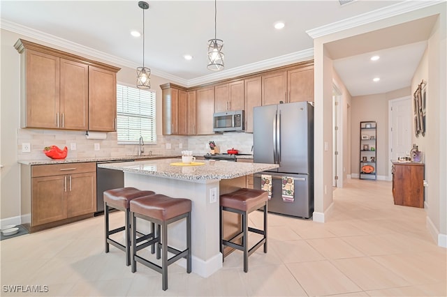 kitchen featuring appliances with stainless steel finishes, backsplash, light stone counters, and a center island