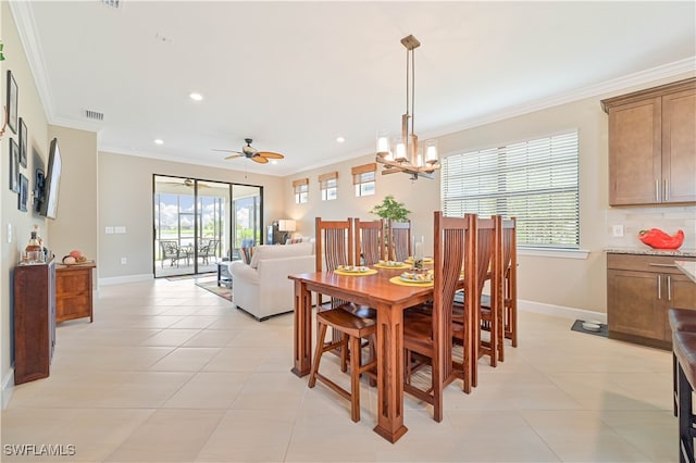 tiled dining space featuring ornamental molding and ceiling fan with notable chandelier